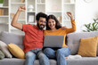 © Prostock-studio - Online Win Joyful Young Indian Couple Celebrating Success With Laptop At Home