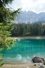 Canvas Print - Vertical shot of Lake Carezza against the background of the Dolomites. South Tyrol, Italy.