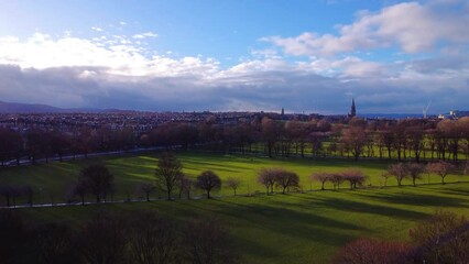 Poster - Raising drone flyover of the city with Edinburgh Castle in the distance with blue sky on the horIzon