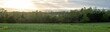 Panoramic of an open field with a majestic sunset in the background