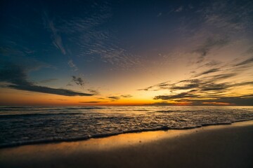 Image of a sunset in the yellow sky from the sea.