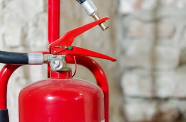 Wall Mural - Closeup of a red fire extinguisher on a blurry background