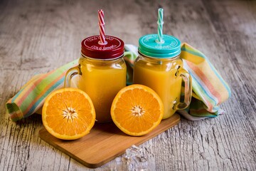 Mason jar with orange lemonade on the table, close-up