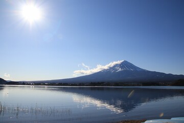 Sticker - Landscape view of the snow-covered mountain reflected in the water against a blue sky