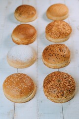 Canvas Print - Vertical shot of the freshly baked bun bread put on the white table surface