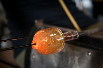 Sticker - Glass blower making orange glass mold with high heat fire for shaping