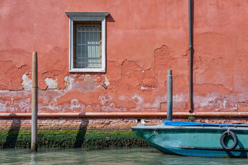 Wall Mural - Picturesque idyllic scene with a boat parked on the water canals in Venice, Italy.