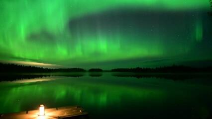 Wall Mural - Timelapse of the glowing Northern Lights over a landscape in Rovaniemi, Lapland, Finland