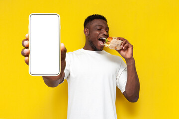 Wall Mural - african american man in white t-shirt holding big burger and showing blank smartphone screen