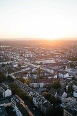 Sticker - A vertical shot of a sunset over a large city. It's summer and the sun is shining in Cologne.