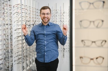 Poster - male client chooing new eyeglasses frame for his new eyeglasses in optical store