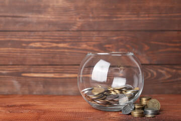 Jar with coins on wooden background. Savings concept