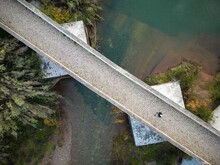 Aerial View Of A Person Standing On A Cobblestone Bridge Above The Shallow River In Portugal