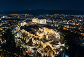 Wall Mural - Aerial night view of the illuminated Parthenon Temple at the Acropolis of Athens, Greece, with the city skyline in the background