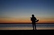 © Markus59/Wirestock Creators - Silhouette of male playing thukulele in front of sea during sunset