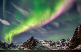 Fototapeta Tęcza - Scenic view of the Northern lights of Norway in the sky behind the rock formations
