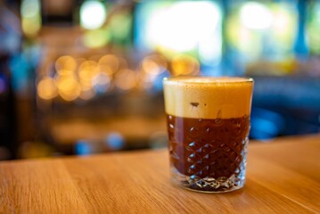 Poster - Iced Coffee Drink in a Crystal Glass a Wooden Bar Table