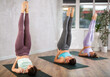 © JackF - Group of women taking care of their physical health and doing yoga in a fitness center perform an exercise standing in a pose .with their legs raised during a workout
