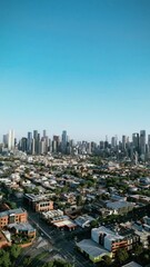 Wall Mural - Vertical aerial footage of a city with urban buildings and skyscrapers in daylight