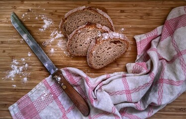 Poster - Top view of slices of bread and a knife on a wooden board