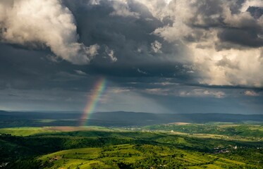 beautiful view of a field with cloudy sky and a rainbow
