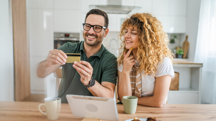 adult couple man and woman shopping online use laptop hold credit card