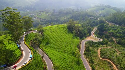 Sticker - Landscape aerial view of cars driving on curvy asphalt roads with meadow with cloudy sky