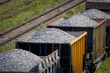 Open freight railway wagons loaded with crushed stone. Freight transportation of bulk building materials by rail. Shot from the top angle
