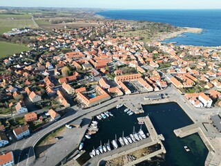 Sticker - an aerial shot of an old marina and small town by the water