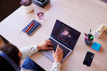 Cropped image of programmer writing code on laptop