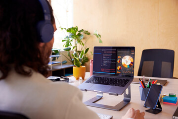 Anonymous male IT specialist working on laptop in office