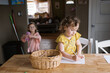 © Serena Burroughs/Stocksy - Little girl in yellow shirt drawing a picture at the kitchen table
