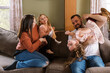 © Serena Burroughs/Stocksy - Smiling happy family playing with kids on couch in home