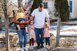© Serena Burroughs/Stocksy - Happy family standing in front of home in spring outdoors