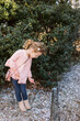 © Serena Burroughs/Stocksy - toddler girl posing in her clothes with a purse and boots in yard