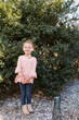 © Serena Burroughs/Stocksy - toddler girl posing in her clothes with a purse and boots in yard