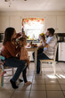 © Serena Burroughs/Stocksy - Mother and father doing their twin's hair together at kitchen table
