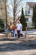 © Serena Burroughs/Stocksy - Happy family standing in front of home in spring outdoors