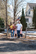 © Serena Burroughs/Stocksy - Happy family standing in front of home in spring outdoors