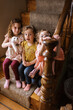 © Serena Burroughs/Stocksy - Three sisters sitting on stairs in home