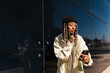 © Ezequiel Giménez/Stocksy - Female using cellphone for applying lipstick on street