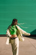 © Ezequiel Giménez/Stocksy - Trendy woman with braids walking on street