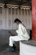 © Ezequiel Giménez/Stocksy - Stylish woman using laptop in loft building near column