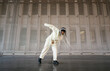 © Ezequiel Giménez/Stocksy - Female hip hop dancer performing in loft hangar