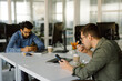 © Oleksii Syrotkin/Stocksy - Coworkers eat table computer relax workplace