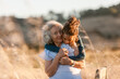 © ByLorena/Stocksy - Senior woman and grandson hugging by the field
