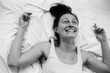 © Sergey Filimonov/Stocksy - Smiling woman lying on bed overhead