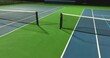 Evening video of outdoor blue tennis courts with pickleball lines with lights turned on.	