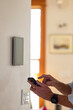 © Raymond Forbes LLC/Stocksy - Smart Home technology Panel in Home with man typing on smarphone app