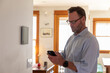 © Raymond Forbes LLC/Stocksy - Smart Home technology Panel in Home for man in glasses